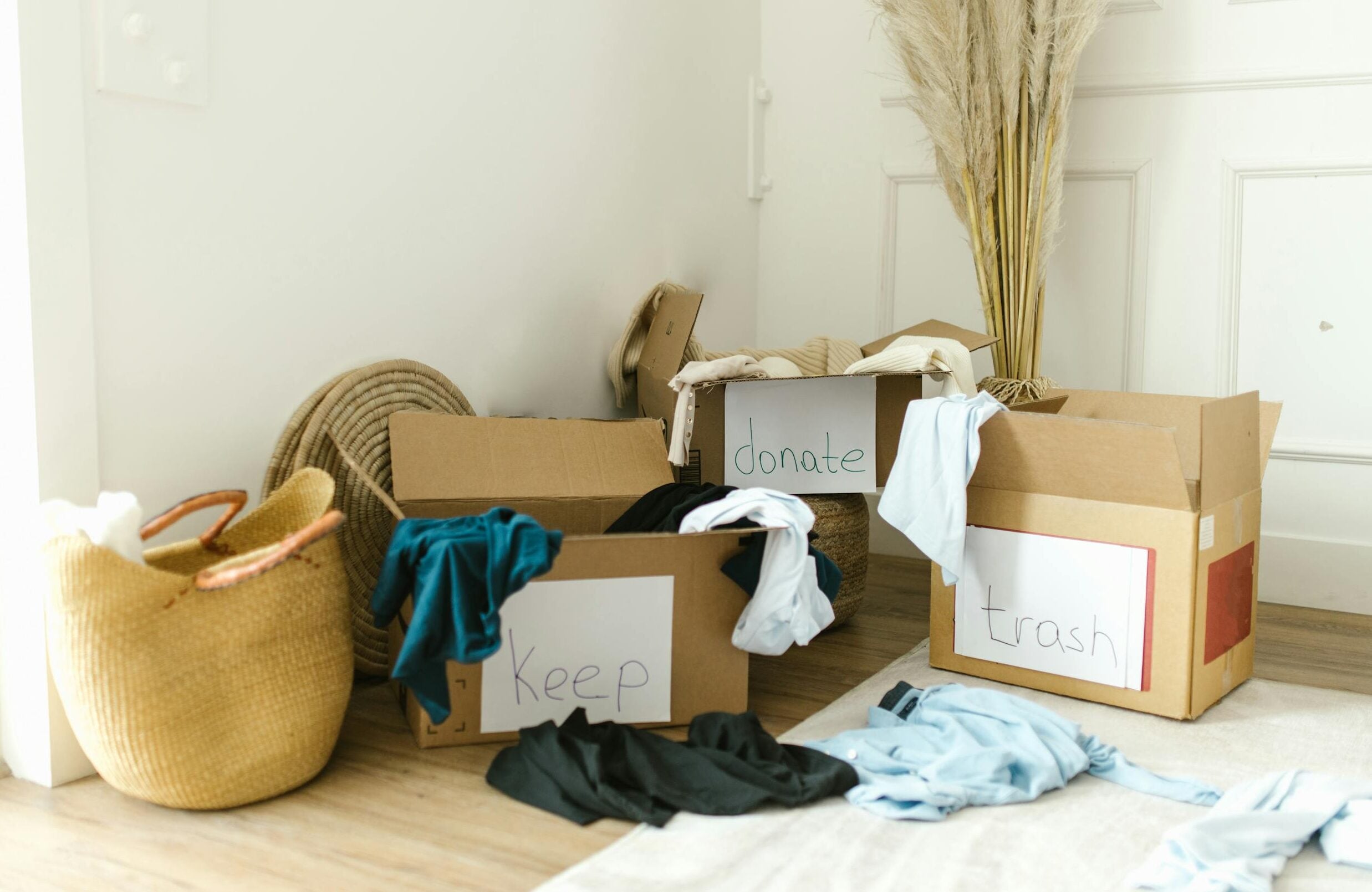 Cardboard boxes labeled 'Keep', 'Donate', and 'Trash' for home decluttering.